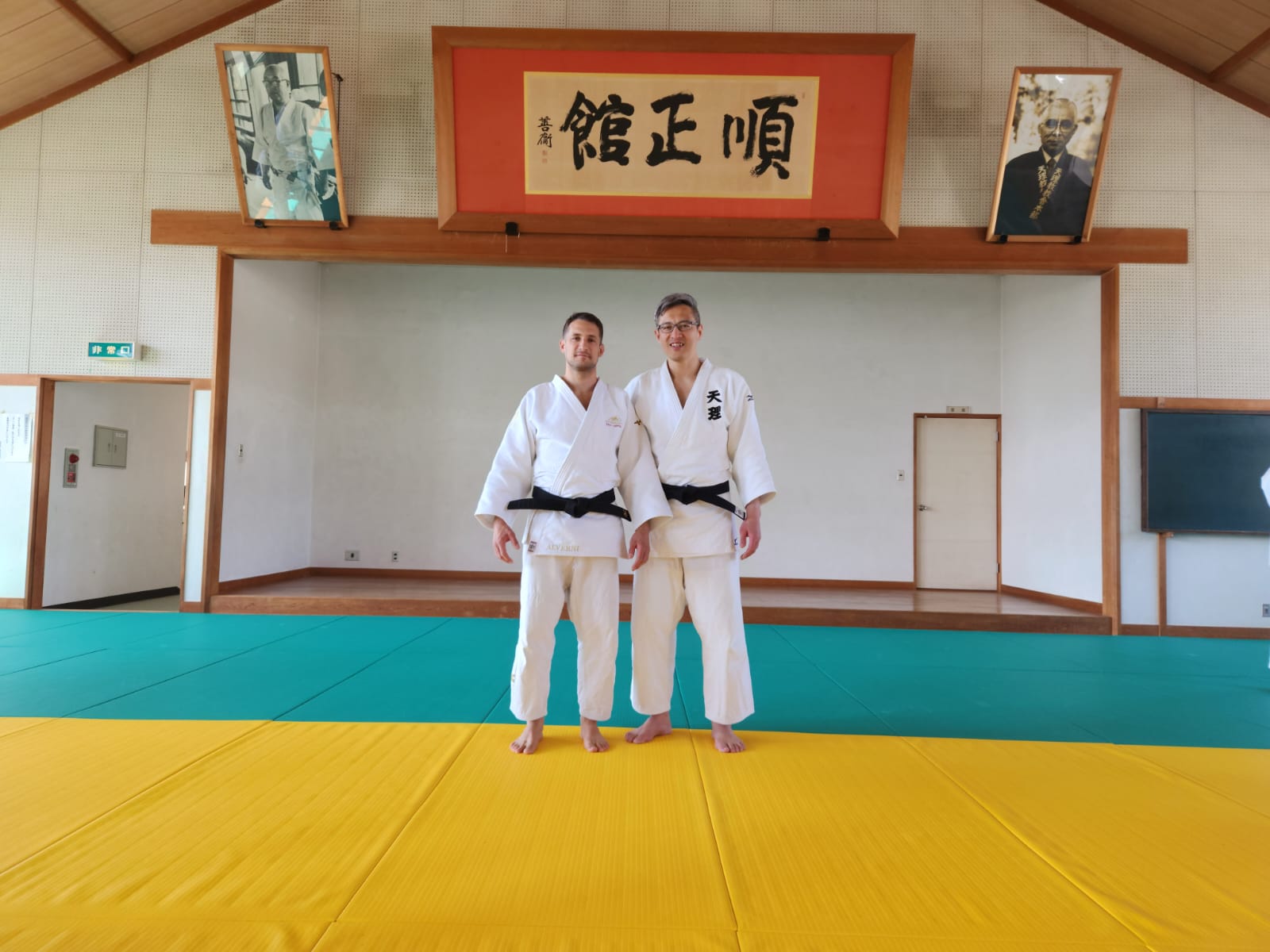Nicolas Alverni dans un dojo au Japon, devant les portraits des fondateurs du judo